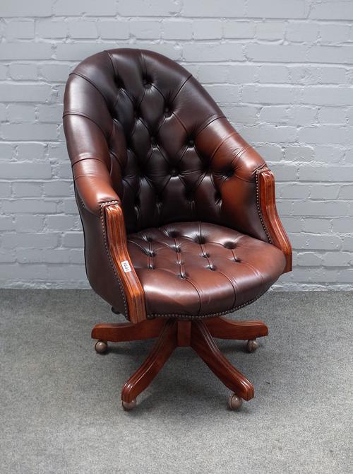 A 20th century studded brown leather upholstered tub back swivel office chair, on five point base, 67cm wide x 105cm high.