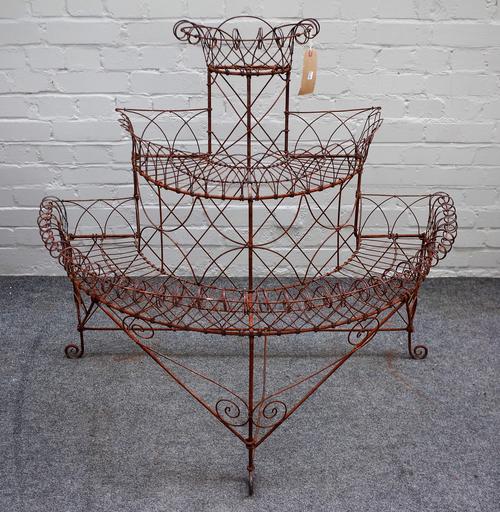 An early 20th century demi-lune three tier wire work plant stand, 114cm wide x 96cm high.