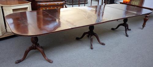 A Regency style mahogany triple pillar extending dining table, on spiral fluted baluster supports and ten down swept supports, two extra leaves and tw