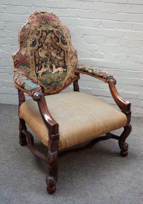 An early 18th century and later walnut framed hump back open armchair, on scroll supports, 73cm wide x 103cm high.