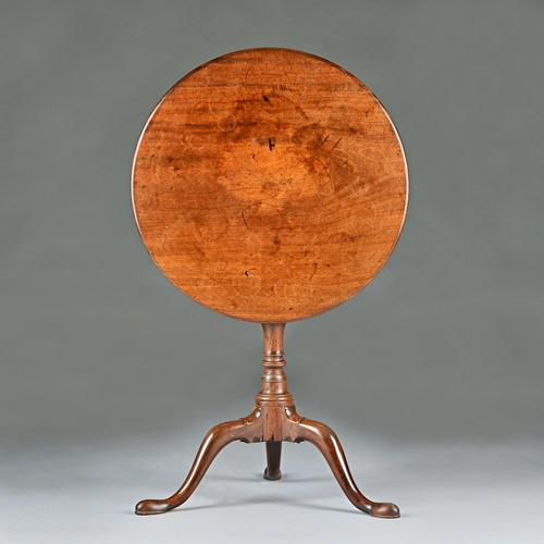 A mid-18th century mahogany tripod occasional table, the circular snap top on bird cage mount and baluster turned column, 60cm diameter x 68cm high. I