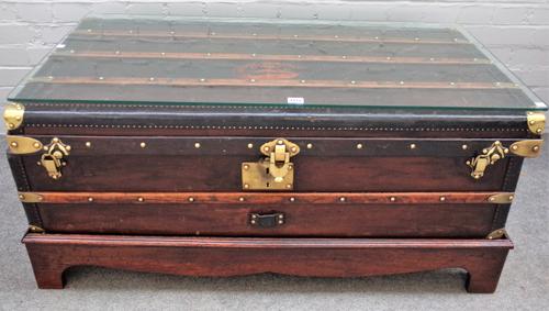 A leather and brass bound steamer trunk/ coffee table, on later stand, 110cm wide x 52cm high.