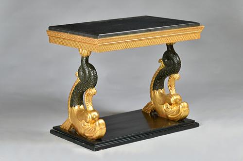 A Russian console table, circa 1830, the later rectangular marble top over a pair of ebonised parcel gilt dolphin supports, 94cm wide x 77cm high. AS