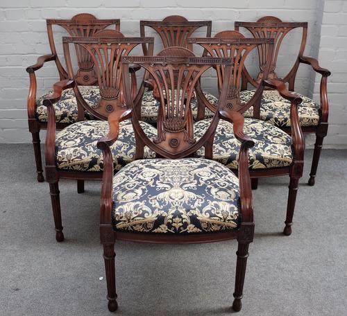 A set of twelve 18th century style mahogany framed open arm/ carver chairs, on tapering reeded supports, 58cm wide x 95cm high, (19th century), (12).