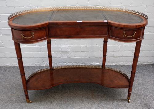 Brights of Nettlebed; a 20th century mahogany kidney shape writing desk, with a pair of frieze drawers and slide centre section on ring turned support
