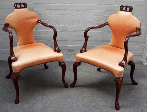 Baker Furniture; a pair of George III style open arm side chairs, with crown crest and hooped back on four cabriole supports, 59cm wide x 96cm high.