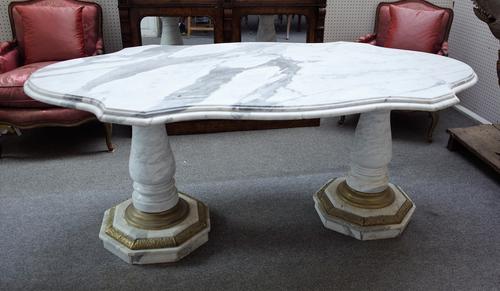 A 20th century marble centre table, the shaped top on a pair of gilt metal mounted baluster columns, 194cm wide x 77cm high.
