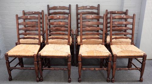 A set of eight 18th century style rush seated ladder back dining chairs, to include a pair of carvers, (8).