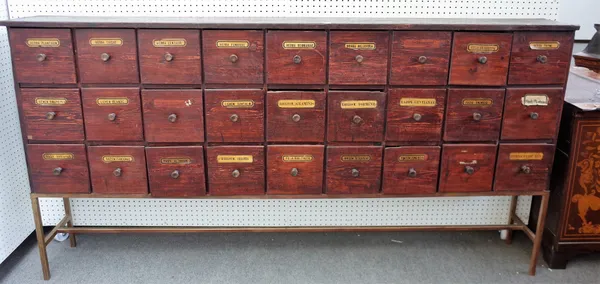 A stained pine apothecary cabinet with three rows of nine drawers, on metal stand, 221cm wide x 114cm high x 30cm deep