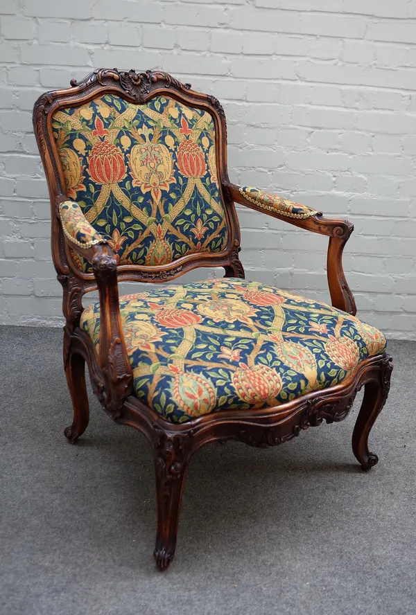 A Louis XV style walnut framed open armchair with serpentine seat and scroll supports, 77cm wide x 100cm high.