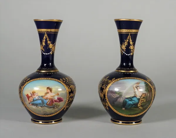 A pair of `Vienna' blue-ground bottle vases, circa 1900, painted with titled scenes, Amor u Venus and Venus, signed Newmann, inside gilt frames agains