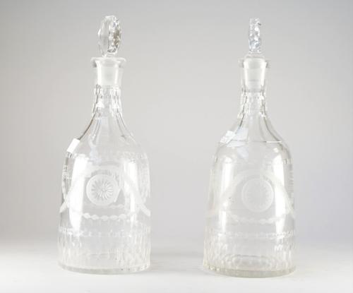 A pair of early 20th century engraved glass decanters and matched stoppers, of sugarloaf form, each engraved with bucrania and patera and neo-classica
