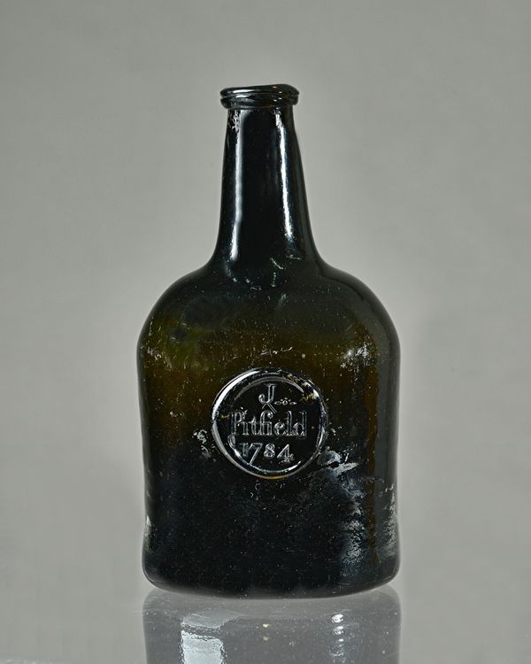 A sealed glass  wine bottle, dated 1784, of dark olive-green tint, the squat cylindrical body applied with a moulded circular seal inscribed `J.Pitfie