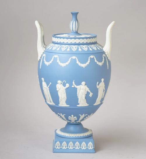 A Wedgwood blue jasper two-handled vase and cover, 20th century, the ovoid body sprigged in white with classical muses beneath undulating flower garla