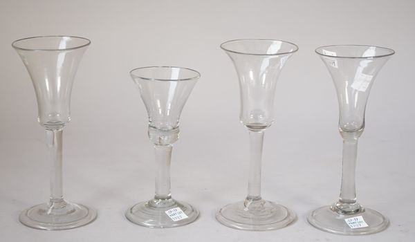 Three plain stemmed wine glasses, 18th/19th century,each with bell bowl and folded foot, tallest 17.75cm; and another wine glass with bell bowl and pl