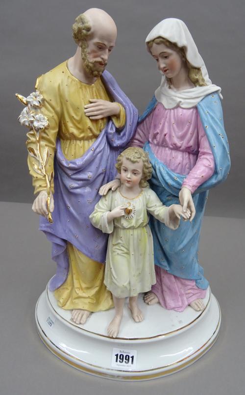 A Continetnal biscuit porcelain figure group, early 20th century, depicting a Holy family group, over an oval gilt lined base. Incised marks, 41cm hig