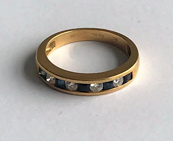 An 18ct gold, sapphire and diamond half-hoop ring,   channel set with alternating circular cut diamonds and calibre cut sapphires, ring size K, weight