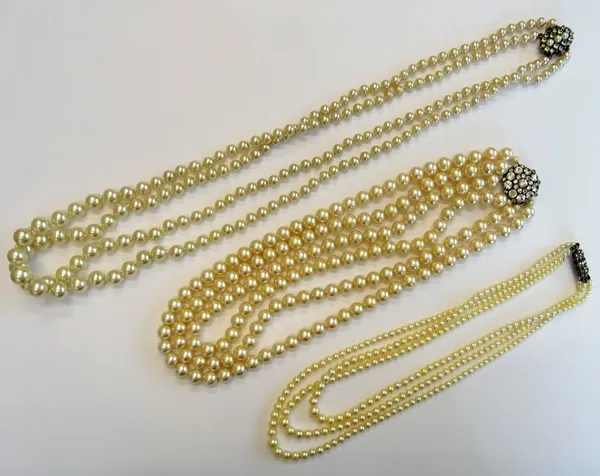 A three row necklace of graduated cultured pearls, on a Sterling silver and marcasite clasp, a three row necklace of imitation pearls, on a colourless