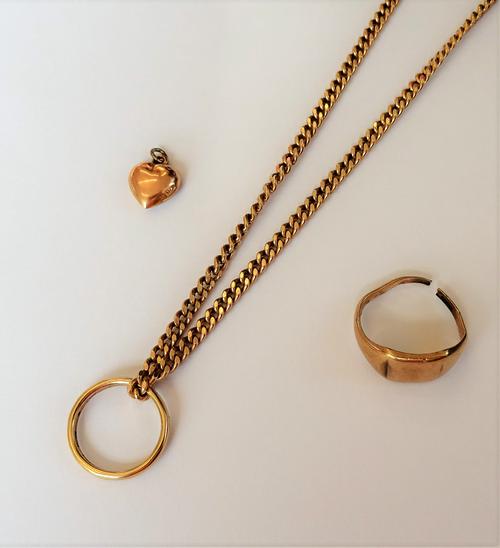 A group of mostly 9ct gold jewellery, comprising; a signet ring, a faceted curb link neckchain, a wedding ring and a small heart shaped charm, gross c