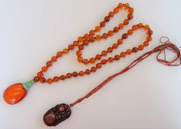 An Asian amber and jade pendant necklace, the front with an oval amber drop, with a jade surmount, fitted to a translucent varicoloured amber bead nec