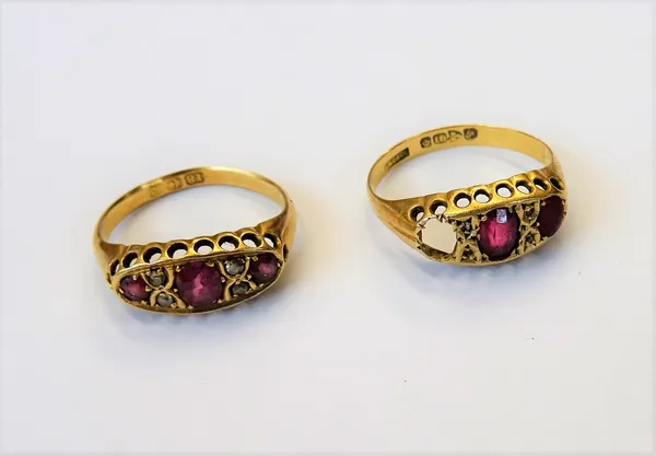 An 18ct gold, ruby and diamond ring, mounted with three rubies, alternating with two pairs of cushion shaped diamonds, Birmingham 1909, ring size M an