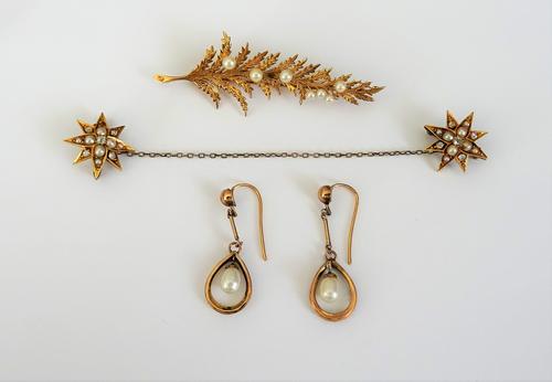 A pair of gold, diamond and half pearl set brooches, each designed as an eight pointed star mounted with cushion shaped diamonds and with half pearls
