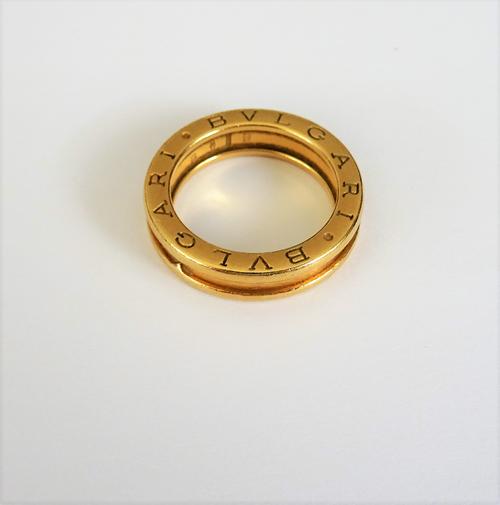 A Bvlgari 18ct gold band ring, having ridged edges, detailed Bvlgari to either side of the band and further detailed 53 750 Made in Italy, ring size M