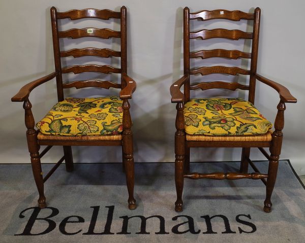 A pair of 18th century style oak ladder back open armchairs, 60cm wide x 106cm high, (2).