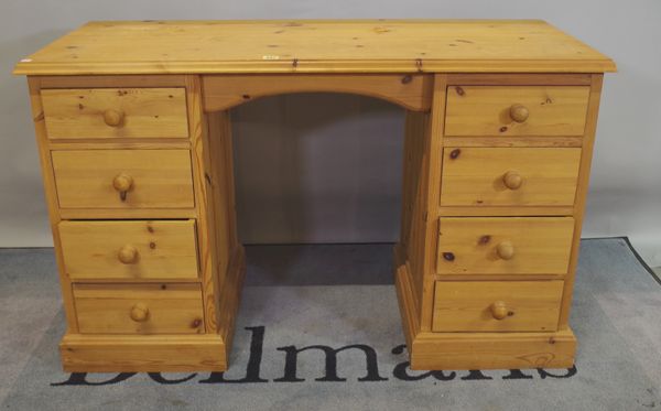 A modern pine pedestal desk comprising eight drawers about the knee, 122cm wide.