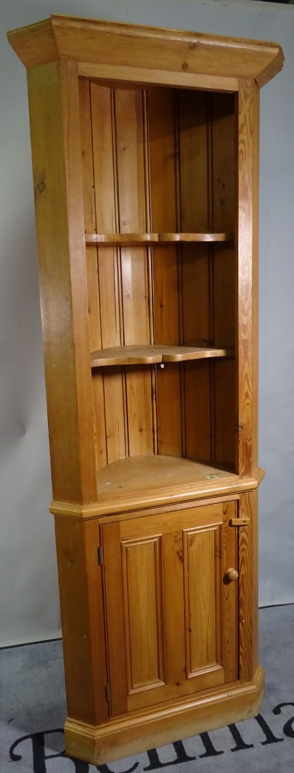 A 20th century pine floor standing corner cabinet, with recessed top over cupboard base, 70cm wide x 198cm high.