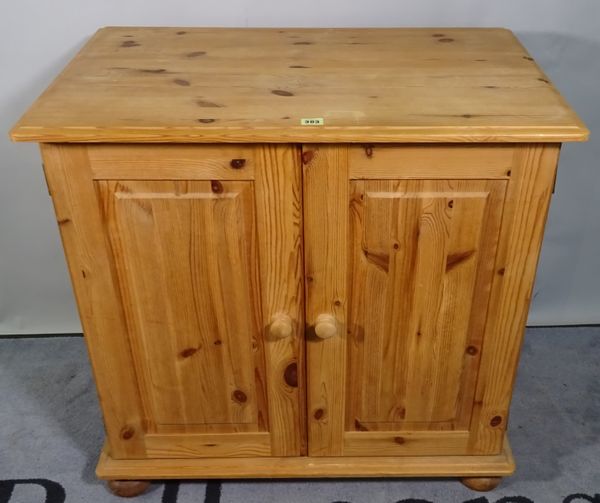 A 20th century pine side cupboard with a pair of panelled doors, 81cm wide x 72cm high.