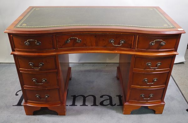 A 20th century yew wood veneered concave pedestal desk with green leather inset top, 119cm wide x 72cm high.