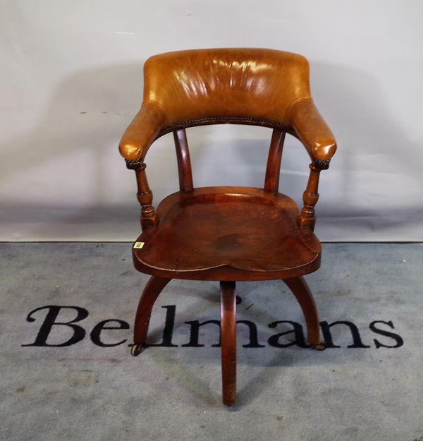 A late 19th century office armchair with elm slab seat and tan studded leather upholstery, 56cm wid x 88cm high.