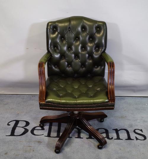 A 20th century Gainsborough style office open armchair with faux green leather button back upholstery, 57cm wide x 94cm high.