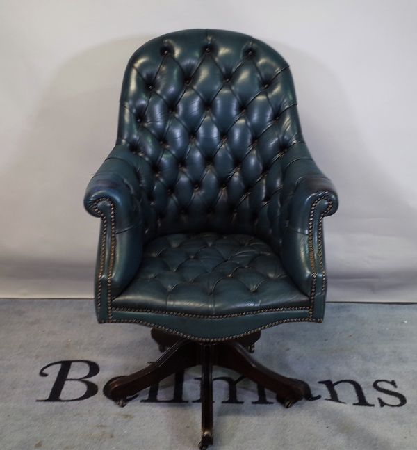 A 20th century Chesterfield style office chair with faux blue leather button back upholstery, 70cm wide x 117cm high.