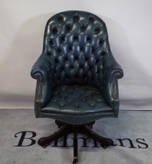A 20th century Chesterfield style office chair with faux blue leather button back upholstery, 70cm wide x 117cm high.