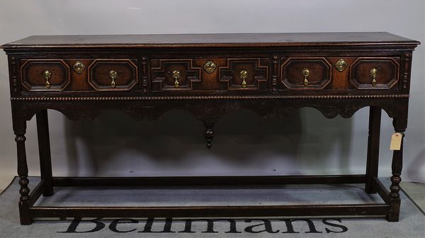 A Charles II and later oak dresser base, with three geometric frieze drawers on turned supports, 174cm wide x 82cm high.