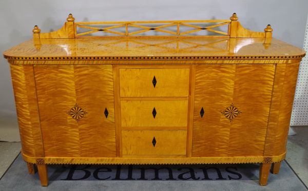 An early 20th century satin birch sideboard, with three drawers flanked by cupboards, 182cm wide x 90cm high.