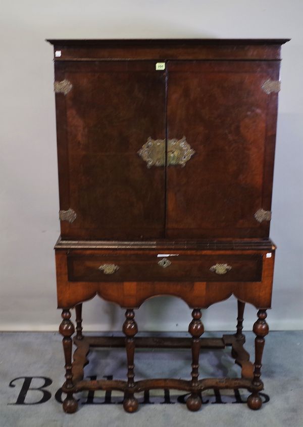 A Queen Anne style figured walnut two door cabinet, on single drawer base, united by shaped stretcher, 93cm wide x 165cm high.