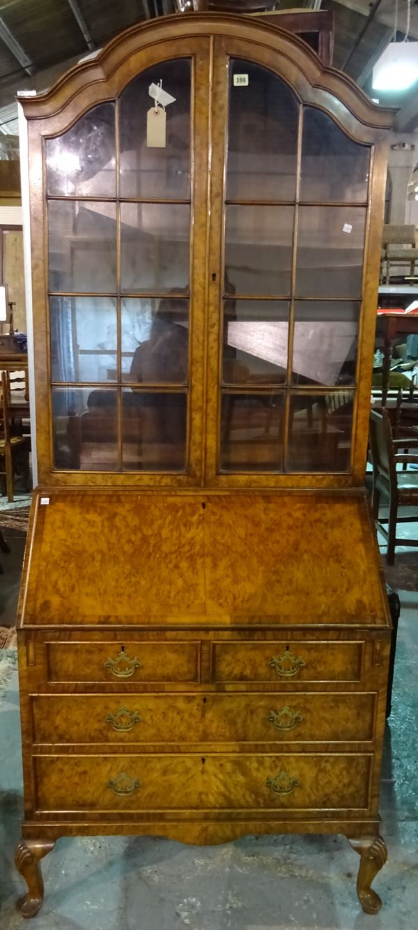 A Queen Anne style figured walnut bureau bookcase, on shell capped cabriole supports, 87cm wide x 207cm high.