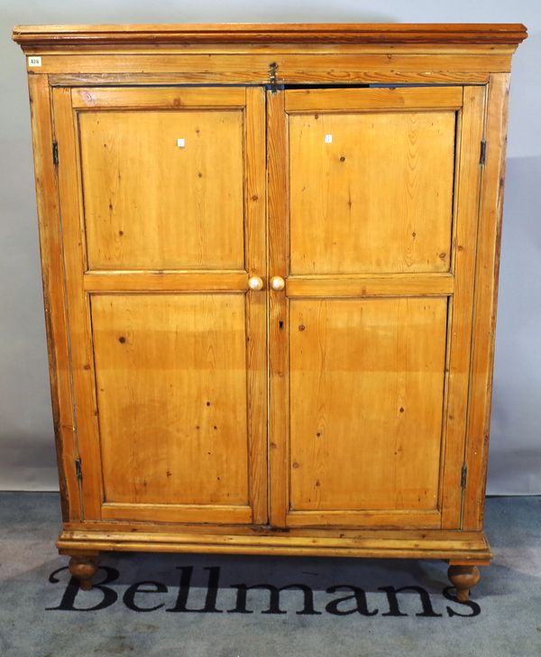 An early 20th century pine wardrobe on tapering supports, 124cm wide x 160cm high.