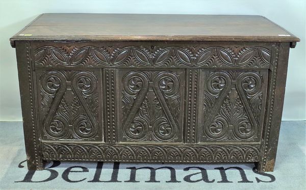 A 17th century and later oak coffer, the twin plank top over carved triple panel front, 129cm wide x 69cm high.