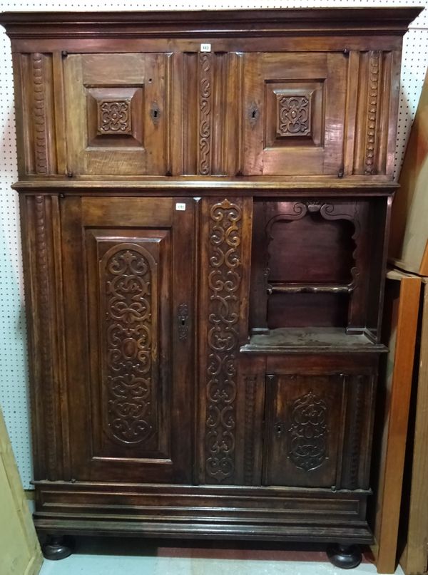 An 18th century and later Continental walnut side cabinet, with an arrangement of raised panelled doors and cupboards, on bun feet, 140cm wide x 205cm