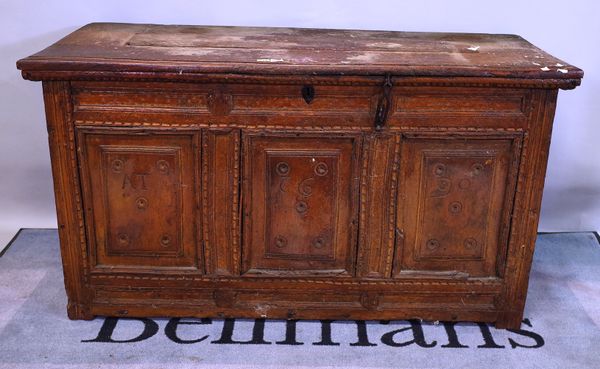 A 17th century French elm coffer, the plank top over carved triple panel front, dated 1690, 135cm wide x 75cm high.