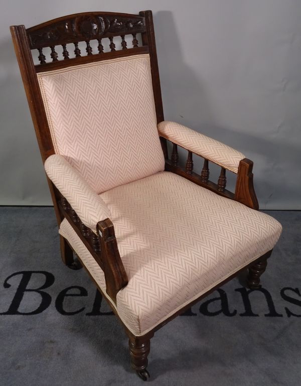 An Edwardian walnut upholstered armchair on turned supports, 66cm wide x 102cm high.