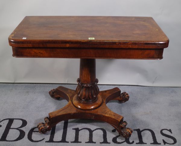 A Victorian rosewood foldover card table with turned central column resting on quatrefoil base, 90cm wide x 70cm high.