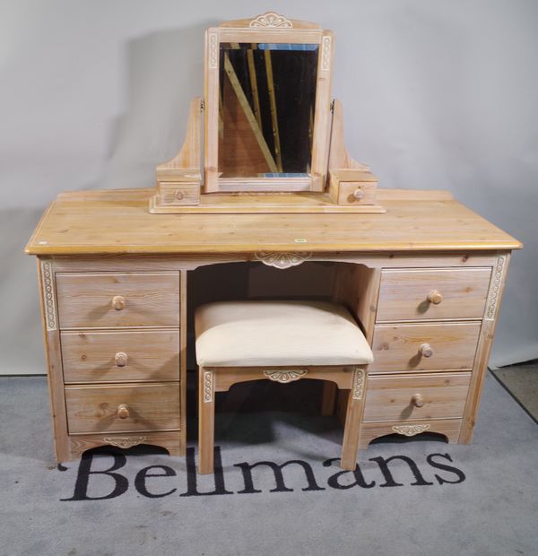 A 20th century pine dressing table with six drawers about the knee and swing frame mirror, 140cm wide x 74cm high and a matching stool, (2).