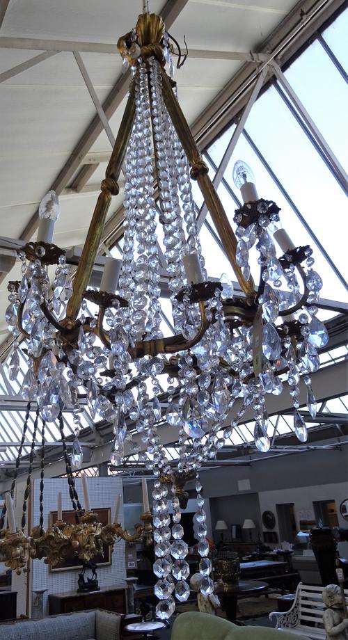 A modern gilt bronze twelve branch chandelier of Victorian style, the three ribbon cast supports over a shaped circlet issuing twelve split level bran