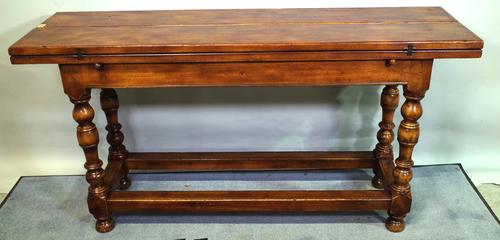 A 17th century style oak extending dining table with hinged rectangular top, 150cm long x 84cm wide x 75cm high.