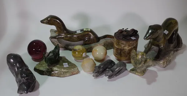 Mostly 20th century carved stone decorative objects, comprising four paperweights, models of otters and a candle holder, (qty). S4B